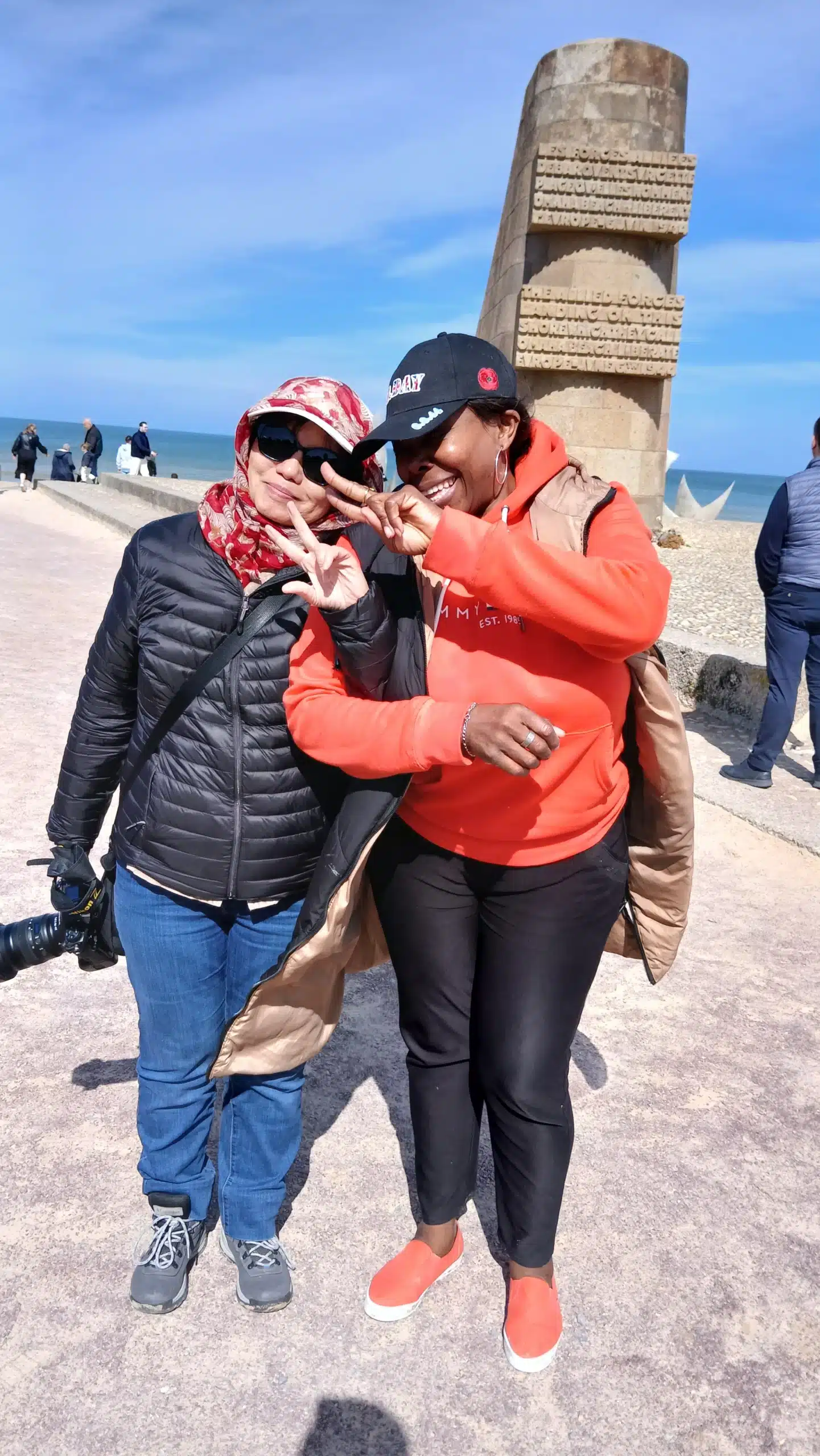 Deux clientes souriantes profitant d'une excursion touristique à Omaha Beach, service de transport VTC Borel Royal.